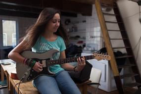 photo of a girl with a guitar in a student apartment