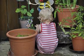 Child Playing with pot flowers on Terrace