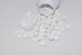 plastic bottle and scattered white pills