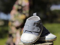 baby boyâs Footwear in front of unrecognizable pregnant woman