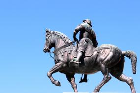 bronze sculpture of a horseman at blue sky