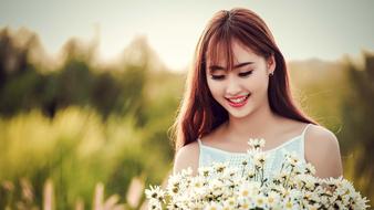 Portrait of the smiling, Asian girl, with the beautiful and colorful flowers, among the colorful plants