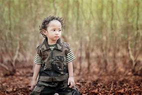 Cute child, among the colorful grass in the park