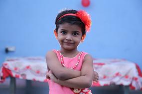 little girl with a flower on her head posing