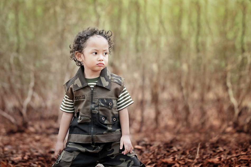 Cute child, among the colorful grass in the park