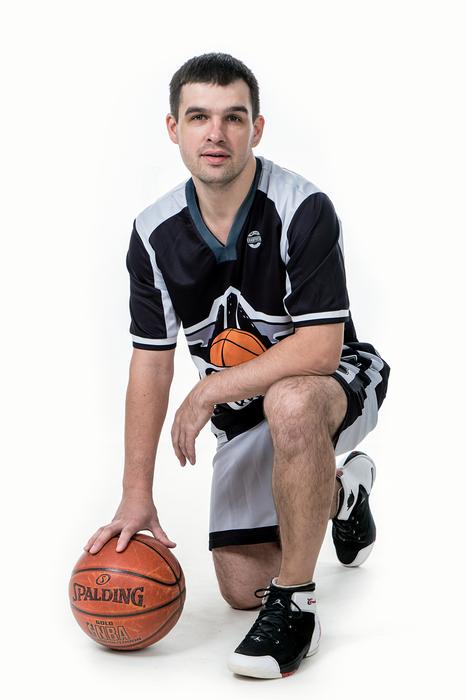 Basketball player, with the ball under the hand, at white background