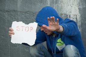 stop inscription and a guy in a blue sweatshirt with a hood