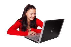 girl in a red sweater near a laptop