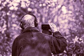 elderly man in headphones in the park in monochrome