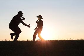 silhouettes of singing father and son at dusk