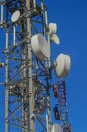 Close-up of the metal telecommunications tower, at blue sky on background