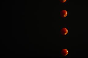falling tomatoes on a black background