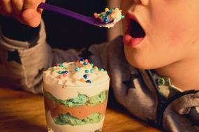 child eats a sweet dessert