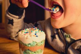 child is enjoying dessert