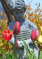 Statue of the girl, among the colorful and beautiful flowers and plants