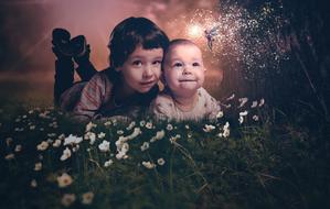 Children posing on the grass and flowers