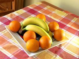 Sweet bananas and oranges on a plate