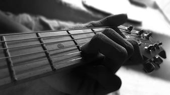 Black and white photo of a person playing on a guitar