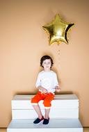 child with a balloon on white steps