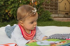 Cute, blonde child playing with the colorful toys outdoors