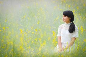 asian girl on the field with yellow flowers