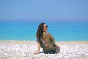 woman with curly hair by the sea, greece