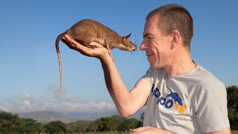 a man with a rat on a blue background