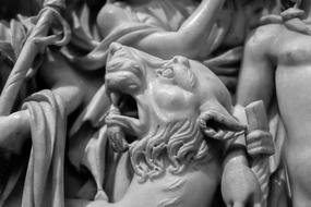 Black and white photo of the shiny marble sculpture of the people and animal, in the museum