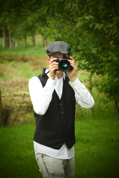 young man in a cap with a camera in the garden