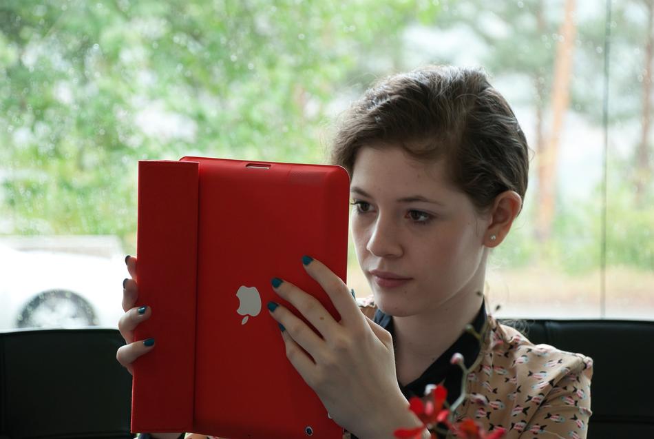 girl looking at ipad in red cover
