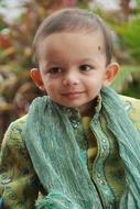 Portrait of the Indian boy in traditional green clothing with patterns