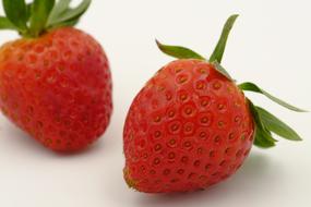 Two juicy strawberries on a white background