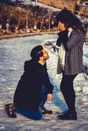 Couple in love, on the beautiful, snowy landscape with plants