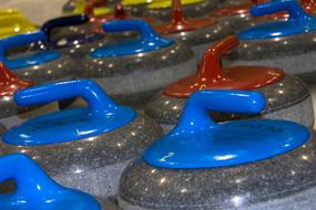 blue, red and yellow curling stones