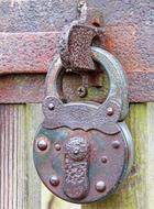 large iron lock on a wooden door close-up