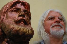 Portrait of the bearded man near the bust sculpture