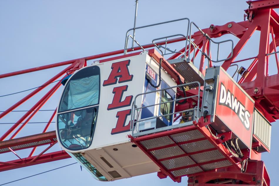 Colorful, metal industrial crane with the signs, at blue sky on background