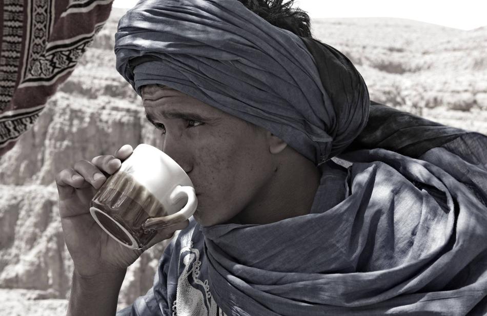 Profile portrait of the person in clothing, drinking from the cup