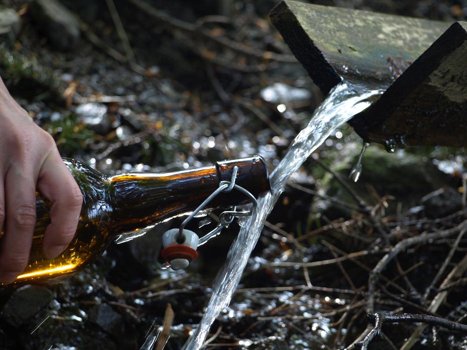 water spring with a bottle in hand