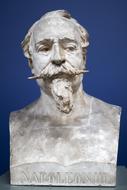 Bust sculpture of the man with moustache, with the sign, at blue background