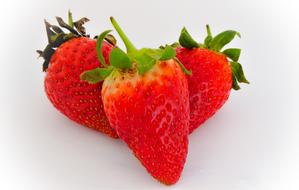 Three sweet strawberries on a white background