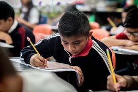 Students writing on the papers, in the school