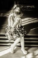 Black and white photo of the sitting girl, in light and shadows