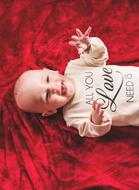 a baby on a red bedspread