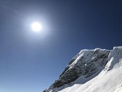 the sun at the mountains with snow