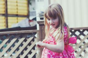 girl with blonde hair in a pink dress