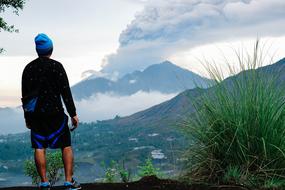 Man in Blue Hat looking at mountain