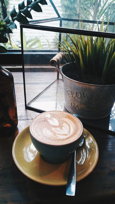 foamy coffee against a backdrop of flowers