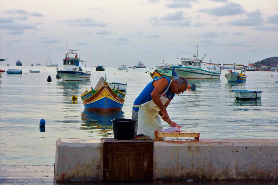 man slicing meat against the sea