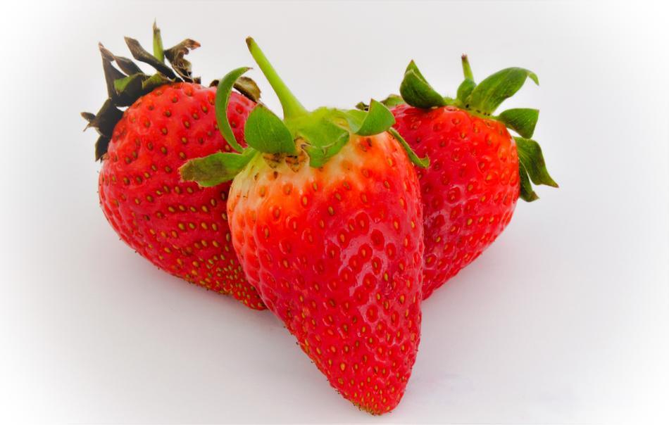 Three sweet strawberries on a white background